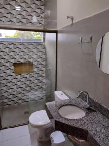 a bathroom with a sink and a toilet and a mirror at Casa Premium em Bonito - Linda e Confortável in Bonito
