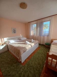 a bedroom with a large bed and two windows at Apartments Simona in Crikvenica