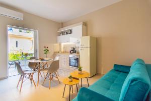 uma sala de estar com um sofá azul e uma cozinha em Vakakis Family Luxury Studios 2 em Palaiochora