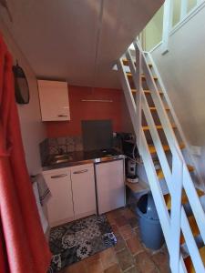 a small kitchen with a staircase leading up to a room at Four à pain in Torcé-en-Charnie