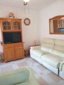a living room with a couch and a flat screen tv at Villas Del Mar 2-bedroom Apartment with Swimming pool in Torrevieja +12 photos