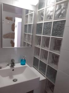 een badkamer met een witte wastafel en een spiegel bij Μεζονέτα - Διώνη- στις Άνω Αρχάνες με οντά in Archanes