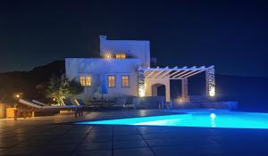 a villa with a swimming pool at night at Kea Ciel Villa in Ioulis