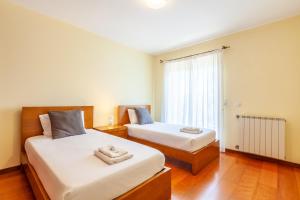 a bedroom with two beds and a window at Casa Faria da Costa in Esposende +32 photos