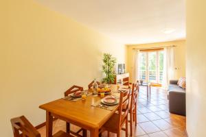 a dining room with a wooden table and chairs at Casa Faria da Costa in Esposende