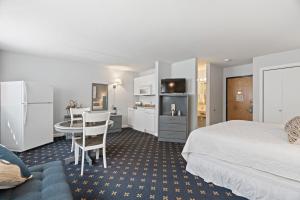 um quarto de hotel com uma cama e uma mesa e uma cozinha em The Niantic Inn em Niantic