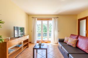 a living room with a couch and a tv at Casa Faria da Costa in Esposende