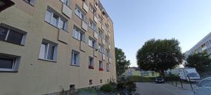 a building with red flowers on the side of it at Black Sails z Parkingiem in Kołobrzeg