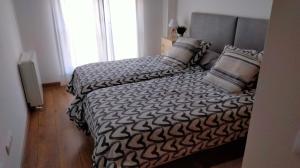 a bedroom with a black and white bed with pillows at La casa de Yeico in Puebla de Lillo