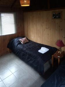 a bedroom with a large bed in a wooden room at Casa al Río in El Chalten