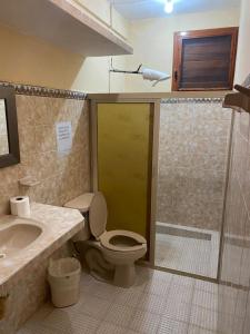 uma casa de banho com um chuveiro, um WC e um lavatório. em Hotel Villa Chic em Progreso