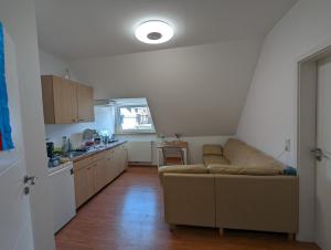 a living room with a couch and a kitchen at Schönes 2 Zimmer Appartment in der Altstadt von Koblenz in Koblenz