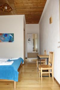 a bedroom with a bed and a table and chairs at Guesthouse Mountain View in Mestia