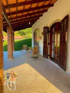 a porch of a house with a table and chairs at Chácara Santa Rita in Bom Jesus dos Perdões