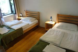 two beds in a room with two lamps on tables at Guesthouse Mountain View in Mestia