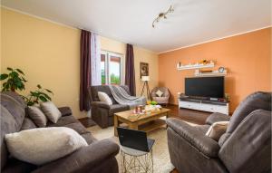 a living room with couches and a flat screen tv at Lovely Home In Sv,lovrec With Kitchen in Stifanići