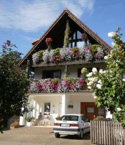 een auto geparkeerd voor een huis met bloemen bij Ferienwohnung Paffendorf in Gutach