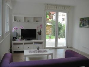 a living room with a purple couch and a tv at Ferienwohnung Paffendorf in Gutach