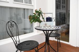 una mesa y 2 sillas en un porche con ventana en Das schiefe Haus Wohnung Festspiele, en Heppenheim an der Bergstrasse