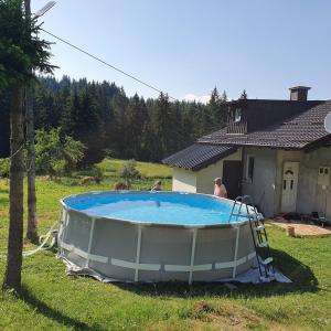 a large swimming pool in the yard of a house at Planinska koliba Ajdanovici Jelovac Nisicka visoravan in Olovo