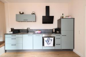 a kitchen with white cabinets and a sink at Das schiefe Haus Wohnung Festspiele in Heppenheim an der Bergstrasse +6 photos