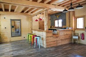 una cocina con taburetes coloridos en una cabaña de madera en La Ferme De L'âne Rouge 7 nuits minimum en Bernex