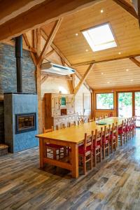 un gran comedor con una gran mesa de madera y sillas en La Ferme De L'âne Rouge 7 nuits minimum, en Bernex