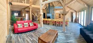 a living room with a red couch and a table at La Ferme De L'âne Rouge 7 nuits minimum in Bernex