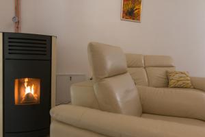 a living room with a couch and a fireplace at Vikendica ''CASA DE TARA'' - Planina Tara in Kaludjerske Bare