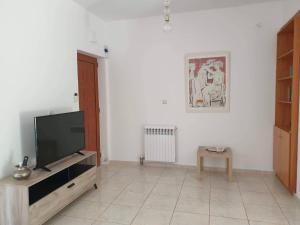 sala de estar con TV de pantalla plana y mesa en Vila Pasiphae, en Arménoi