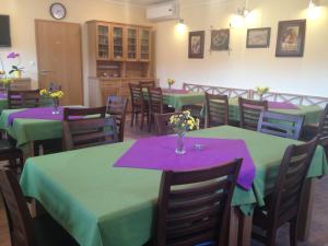 uma sala de jantar com mesas e cadeiras verdes e roxas em Hostel Strug em Makole