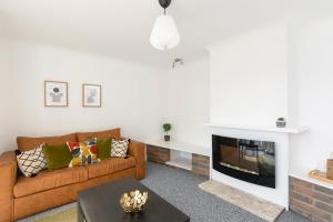a living room with a couch and a fireplace at Parkside House in Stevenage