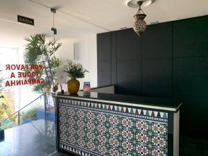 a kitchen with a black wall and a counter at Pousada Elxadai in Guarapari