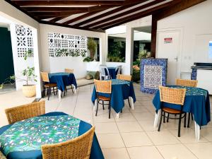 un restaurante con mesas azules y sillas en un patio en Pousada Elxadai, en Guarapari