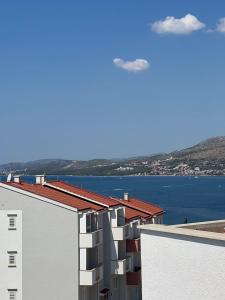 a white building with a view of the water at Apartmani Levarda in Trogir