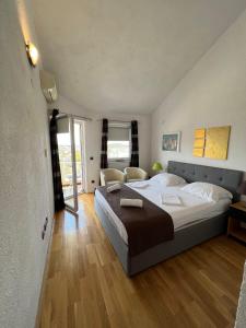 1 dormitorio con 1 cama grande y suelo de madera en Apartmani Levarda, en Trogir