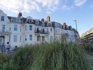uma fila de casas ao lado de uma rua em Beachfront Apartment with BBQ Sun Deck em Bournemouth