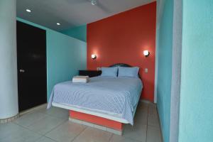 Schlafzimmer mit einem Bett mit roten und blauen Wänden in der Unterkunft Los Angeles en el Paraiso in San Patricio - Melaque