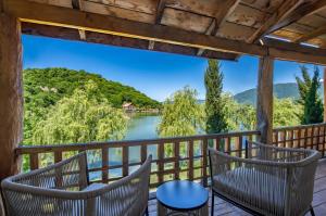 a balcony with chairs and a view of a river at Lopota Lake Resort & Spa in Napareuli