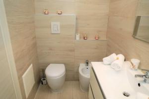 ein Badezimmer mit einem weißen WC und einem Waschbecken in der Unterkunft Delicious Home Fondi in Fondi