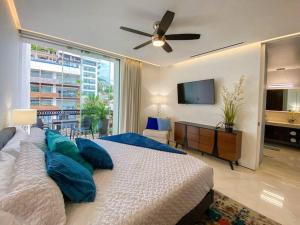 a bedroom with a large bed and a flat screen tv at Luxury Oceanview Modern Condo in Puerto Vallarta