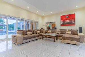 - un grand salon avec un grand canapé et une table dans l'établissement Pattaya Luxury 4BR Pool Villa-BBQ, Karaoke & Pool Table for Families & Group of Travellers, à Nong Prue