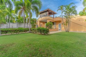une maison avec des palmiers devant une cour dans l'établissement Pattaya Luxury 4BR Pool Villa-BBQ, Karaoke & Pool Table for Families & Group of Travellers, à Nong Prue