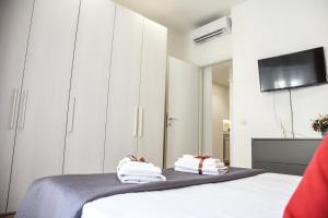 a bedroom with white cabinets and towels on a bed at La casetta di Lulù in Nettuno