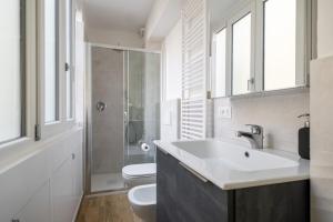 La salle de bains est pourvue d'un lavabo, de toilettes et de fenêtres. dans l'établissement Bologna Suite Centre City, à Bologne