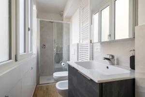 a bathroom with a sink and a toilet and windows at Bologna Suite Centre City in Bologna