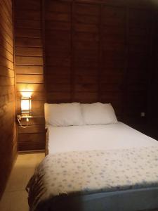 a bedroom with a bed and a light on the wall at Cabanas Alamanda do Rosa in Imbituba
