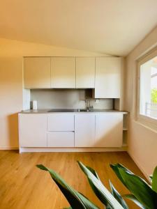 a kitchen with white cabinets and a window at Il Palazzetto - La terrazza di Elia in Cividale del Friuli +28 photos