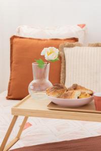 a table with a plate of bread and a vase at Cosy et comfort studio équipé à Clichy 5 min Métro in Clichy