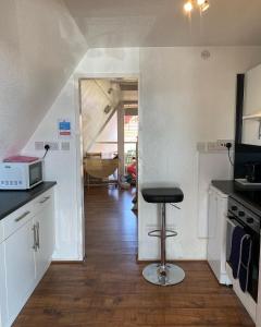 a kitchen with a stool in the middle of a room at Kingsdown Chalet in Deal